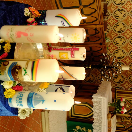 Taufkerzen am Taufbecken in St. Cäcilien in Sehlem